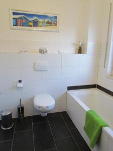 a bathroom with a toilet and a bath tub at Haus am Leuchtfeuer A in Peenemünde