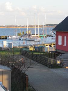a marina with boats in the water and a red building at Haus am Leuchtfeuer A in Peenemünde