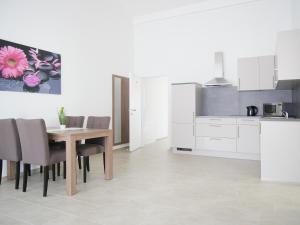 una cucina e una sala da pranzo con tavolo e sedie di Hotel & Mühlenapartments a Gernsbach