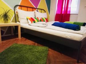 - un lit avec des oreillers colorés et un tapis vert dans l'établissement Budapest Party Hostel at Udvarom, à Budapest
