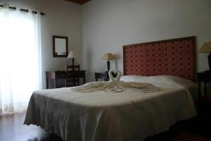 a bedroom with a large bed with a red headboard at Urzelina GuestHouse in Urzelina