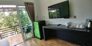 a room with a desk with a television on the wall at โรงแรม ทิพย์บุรี ริเวอร์ไซค์ in Sichon
