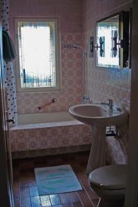 a bathroom with a sink and a tub and a toilet at Landhaus Christophorus in Mallnitz