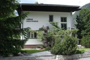 un bâtiment blanc avec un panneau sur son côté dans l'établissement Landhaus Christophorus, à Mallnitz