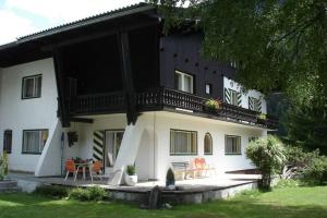 ein Haus mit einem Balkon, einem Tisch und Stühlen in der Unterkunft Landhaus Christophorus in Mallnitz
