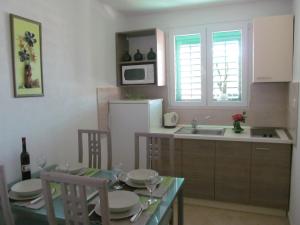a kitchen with a table and a sink and a microwave at Apartment Danese Promajna in Promajna