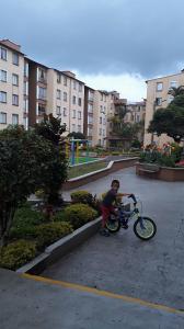 a young boy is playing with a bike in a parking lot at Torres del rio in Armenia