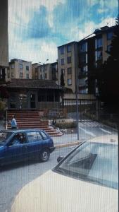 a blue car parked in a parking lot with buildings at Torres del rio in Armenia
