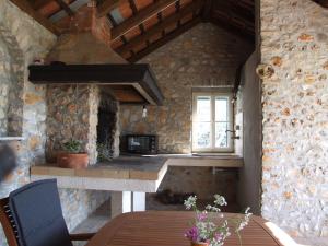 a stone kitchen with a table and a window at Holiday Home Katia in Pučišća