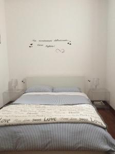 ペルージャにあるB&B IL FRASSINOのベッドルーム1室(壁に文字が付いたベッド1台付)