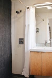 a bathroom with a white shower curtain and a sink at Heliotrope Hotel in Bellingham