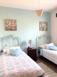 1 dormitorio con 2 camas y mesa con lámpara en Mi trocito de Cielo Ayamonte, en Ayamonte