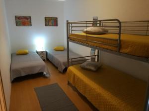サン・マルティーニョ・ド・ポルトにあるSão Martinho do Portoの二段ベッド2台とラグが備わる客室です。