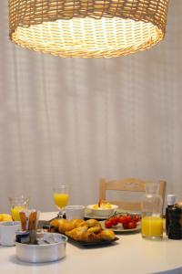 a table with a plate of food and orange juice at Agave Santorini Design Boutique Hotel in Imerovigli