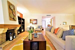 クアルテイラにあるT3 Vila Sol Villageのソファと暖炉のあるリビングルーム