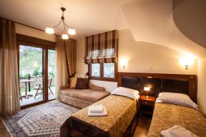 a hotel room with two beds and a couch at Guesthouse Thea in Naousa