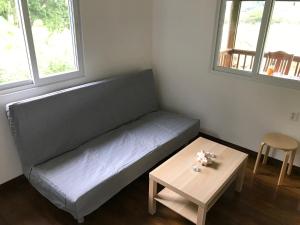 a couch in a room with a table and two windows at Mariposaapartments in Arrozal