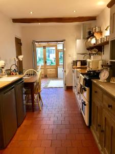 a kitchen with a table and a stove top oven at Bells Cottage in Alderton