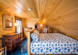 une chambre avec un lit et un plafond en bois dans l'établissement Beach Cottage Inn, à Lincolnville