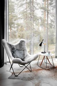 una silla y una mesa en una habitación con ventana en Arctic TreeHouse Hotel en Rovaniemi