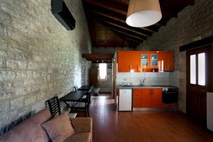 a kitchen with orange cabinets and a table and chairs at Asfendamos in Zacharo