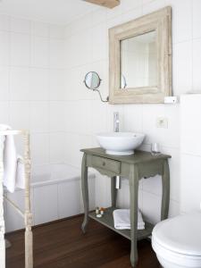 ein Badezimmer mit Waschbecken, Spiegel und Badewanne in der Unterkunft B&B Cimbarsaca in Semmerzake