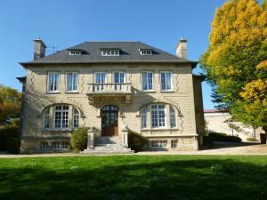 a large stone house on a green lawn at La chambre au Château in Pernant