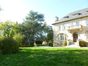 a large house with a green lawn in front of it at La chambre au Château in Pernant