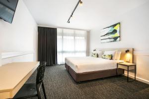 
a hotel room with a large bed and a large window at Nightcap at Matthew Flinders Hotel in Chadstone

