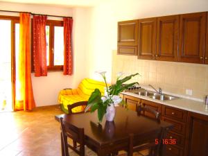 uma cozinha com uma mesa com um vaso de flores em Apartment Valentina em Tergu