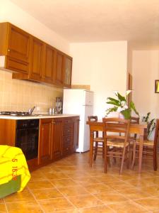 uma cozinha com armários de madeira, uma mesa e uma sala de jantar em Apartment Valentina em Tergu