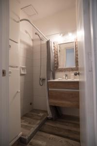 a bathroom with a shower and a sink and a mirror at Aparthotel la Música y el Mar in Maldonado