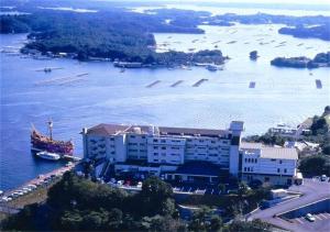 a building next to a river with boats in it at Kashikojima Park Hotel Michishio in Shima