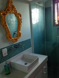ein Bad mit einem Waschbecken und einem Spiegel in der Unterkunft Charme no Centro in Cunha