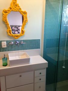 a bathroom with a sink and a mirror and a shower at Charme no Centro in Cunha