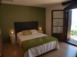 a bedroom with a large bed and a large window at El Mirador de Ainsa in Aínsa