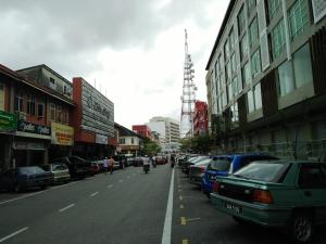 une rue de la ville avec des voitures garées sur le côté de la route dans l'établissement Best Studio Guest House, à Kota Bharu