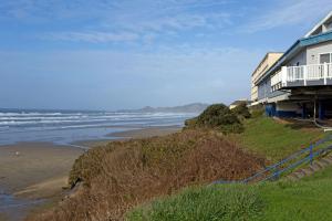 a house on a hill next to a beach at Seagrass Oceanfront Inn in Newport