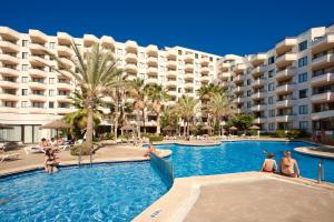 a swimming pool in front of a large building at TRH Jardín Del Mar in Santa Ponsa