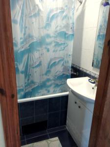 a bathroom with a sink and a shower curtain at Квартиры in Izyum