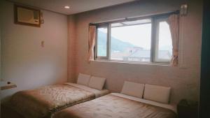 Guiju Lin Garden Homestay في نانزوانج: غرفة صغيرة بها سرير ونافذة