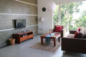 sala de estar con sofá y TV en Villa Babeh, en Bandung