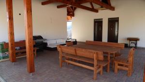 une salle à manger avec une table et des bancs en bois dans l'établissement Apartmány pod Kraličákem, à Dolní Morava