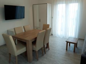 a dining room with a wooden table and chairs at Apartmani Vinko Bol in Bol