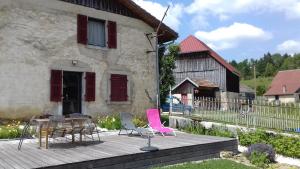 un patio con sillas, una mesa y un edificio en La Petite Forge, en Oye-et-Pallet
