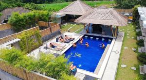 an overhead view of a swimming pool with people in it at Castaway Hostel in Canggu