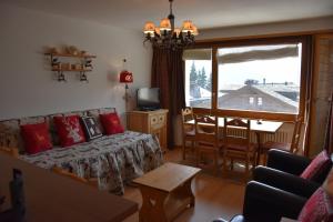 un soggiorno con un divano, un tavolo e una finestra di Bruyères B22 a Verbier