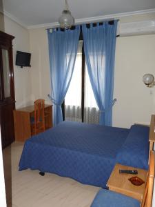 a bedroom with a blue bed and a window at Hostal Fernandez in Madrid