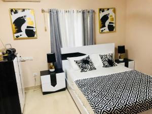 a bedroom with a black and white bed and a window at Westland Villa in Accra