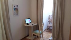 einen Laptop auf einem Tisch mit Stuhl in der Unterkunft "NAR" Opatija center spacious 1 bedroom apt in Opatija